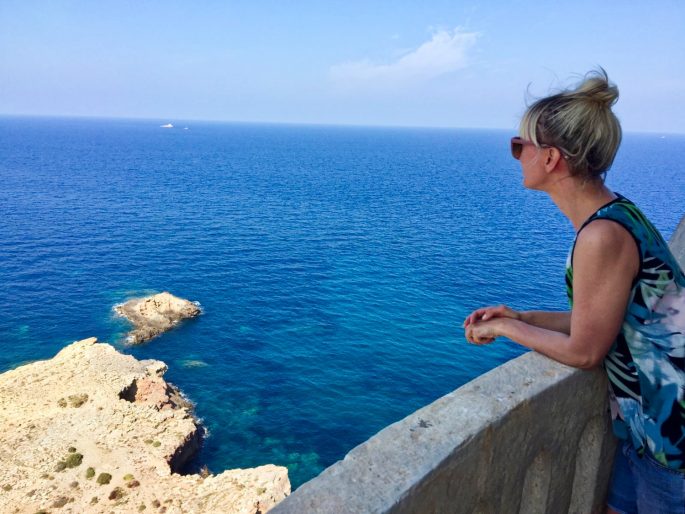 writer looking at the view of the sea from the lighthouse